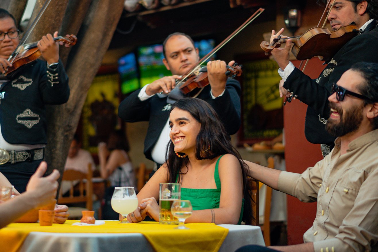 Group of Friends Eating while Listening to Mariachi Band